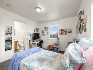 Bedroom featuring an extra window due to being an end unit, carpet floors and connected bathroom