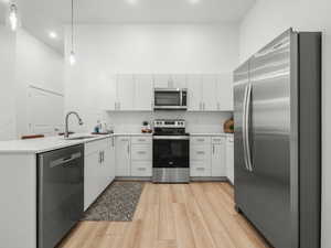 Kitchen with stainless steel appliances, quartz counters, tile backsplash