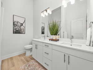 Full primary bathroom with double vanity, quartz counters and walk in closet.