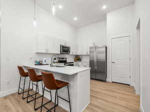 Kitchen with stainless steel appliances, quartz counters, tile backsplash