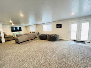 Living room featuring light carpet, baseboards, a textured ceiling, french doors, and recessed lighting