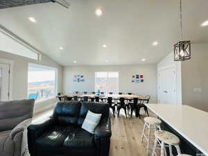 Interior space featuring light wood-style floors, lofted ceiling, a textured ceiling, and recessed lighting