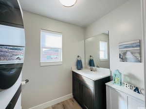 Bathroom featuring wood finished floors, vanity, and baseboards