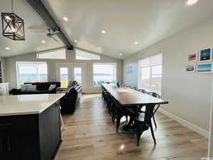 Dining room with lofted ceiling with beams, light wood-style flooring, and a healthy amount of sunlight