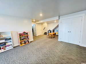 Rec room with baseboards, a textured ceiling, carpet flooring, and recessed lighting