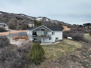 Rear view of property featuring a lawn, a mountain view, a patio area, and french doors