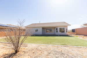 Back of property with a yard, fence, and stucco siding