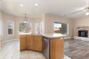 Kitchen featuring light countertops, open floor plan, a sink, plenty of natural light, and dishwasher