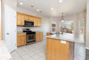 Kitchen with light tile patterned floors, stainless steel appliances, a sink, visible vents, and light countertops