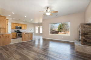 Unfurnished living room featuring a ceiling fan, recessed lighting, baseboards, and light wood finished floors