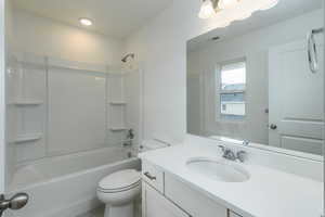 Bathroom featuring toilet, shower / bath combination, vanity, and visible vents