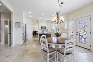 Dining room featuring recessed lighting, light tile patterned floors, baseboards, and an inviting chandelier