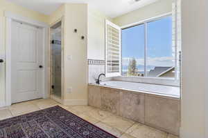 Full bathroom with a shower stall, visible vents, baseboards, and a bath