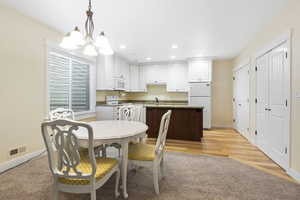 Dining area featuring light wood-style floors, baseboards, visible vents, and recessed lighting