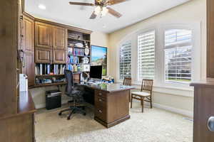 Office space with light carpet, visible vents, and baseboards