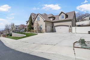 View of front of property featuring stone siding, fence, and stucco siding