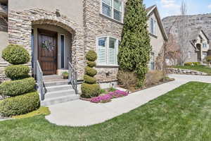 Entrance to property with stone siding and stucco siding