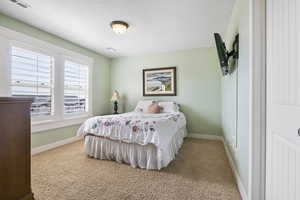 Carpeted bedroom with visible vents and baseboards