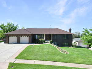 Ranch-style house with an attached garage, concrete driveway, a front lawn, and brick siding