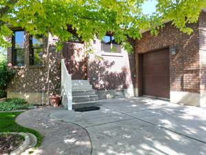 Exterior space featuring brick siding, a garage, and concrete driveway