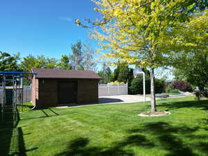 View of yard with a playground, an outdoor structure, and a patio
