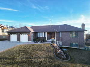 Ranch-style house with an attached garage, brick siding, driveway, and a chimney