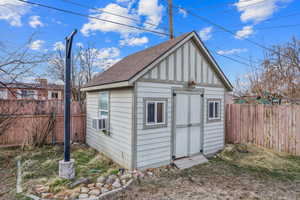 View of shed featuring cooling unit and a fenced backyard