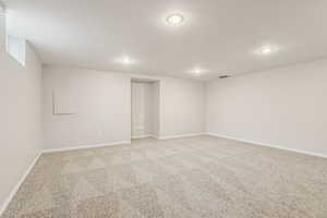 Empty room with recessed lighting, visible vents, baseboards, and light colored carpet