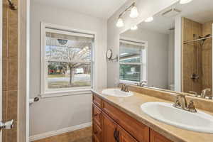 Full bath with toilet, a sink, visible vents, and baseboards