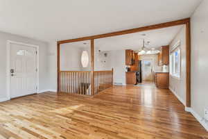 Foyer entrance with light wood-type flooring, baseboards, and visible vents