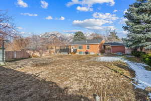 View of front of house featuring fence, a mountain view, and brick siding