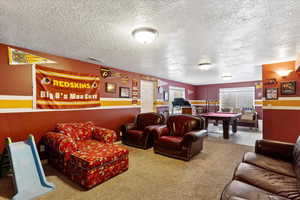 Interior space with a textured ceiling, billiards, carpet flooring, and visible vents