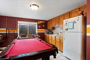 Rec room featuring pool table, a sink, and a textured ceiling