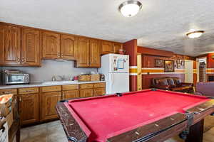 Playroom featuring a toaster, a textured ceiling, a sink, and pool table