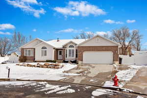 Ranch-style home featuring a garage, driveway, a gate, fence, and brick siding