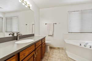 Bathroom featuring baseboards, vanity, and toilet