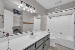 Full bathroom featuring toilet, washtub / shower combination, vanity, and visible vents