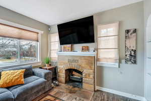 Living room featuring a fireplace, baseboards, and dark wood-style flooring