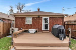 Wooden terrace with cooling unit, a grill, and fence