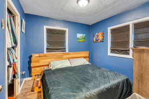 Bedroom featuring a textured ceiling and wood finished floors