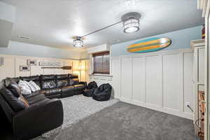 Carpeted living room with a textured ceiling