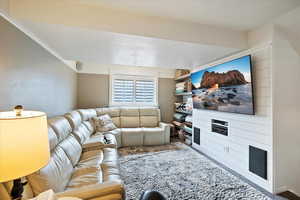 Living room with vaulted ceiling, carpet floors, and a textured ceiling