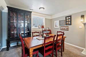 Carpeted dining space with a textured ceiling