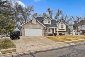 View of front facade featuring a garage and a front lawn