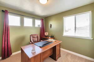 Office space featuring light colored carpet and baseboards