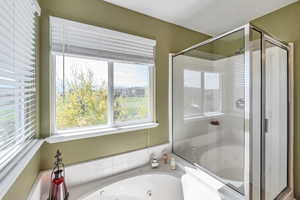 Bathroom with a stall shower and a jetted tub