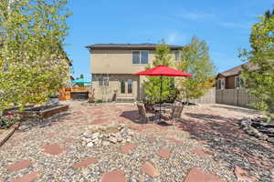 Back of property with entry steps, a patio area, a fenced backyard, and stucco siding