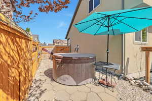 View of patio with a fenced backyard and a hot tub