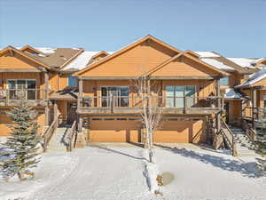 View of front of house with stairs, board and batten siding, and a garage