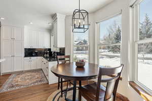 Dining room with dark wood-style floors, recessed lighting, and a chandelier